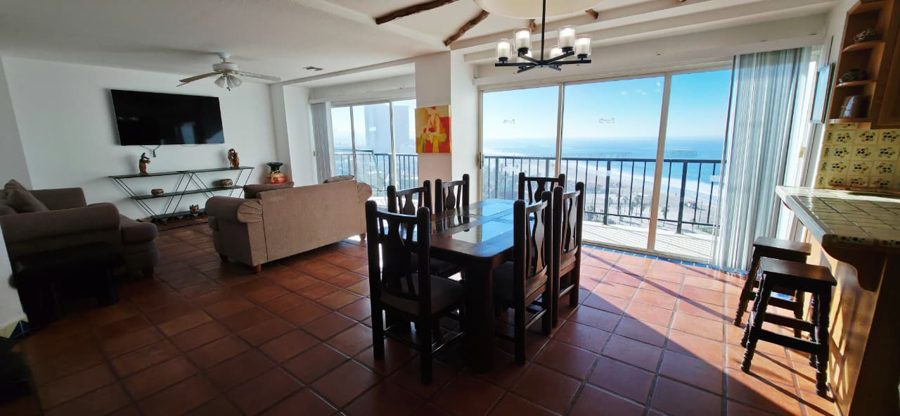 Living and dining room of a 3-bedroom condo with ocean light