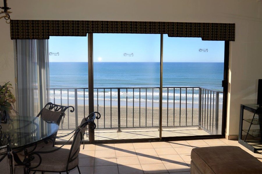 Living room of a 4-bedroom condo with a balcony facing the ocean